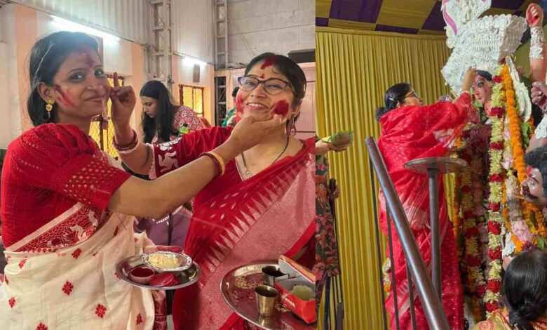 वसुंधरा कालीबाड़ी में सिंदूरखेला उत्सव के दौरान पारंपरिक साड़ी पहने उत्साहित महिलाएं एक-दूसरे के चेहरे और माथे पर सिंदूर लगा रही हैं।