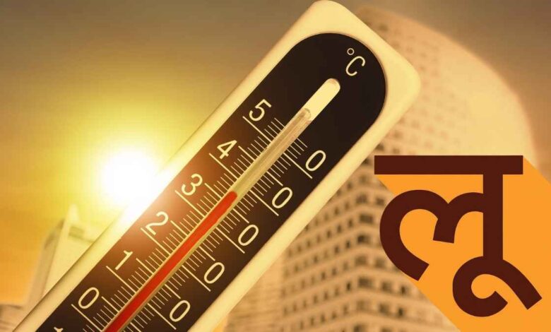 भीषण गर्मी में धूप से बचने के लिए छाता और गमछा इस्तेमाल करता व्यक्ति