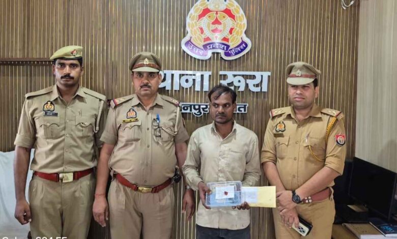 रूरा थाना पुलिस की गिरफ्त में खड़ा लूट का आरोपी विश्वनाथ दोहरे और बरामद अपाचे मोटरसाइकिल