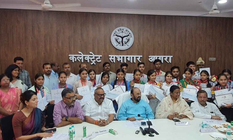 आगरा कलेक्ट्रेट में मेधावी छात्रों को चेक और मेडल देकर सम्मानित करते अतिथि।