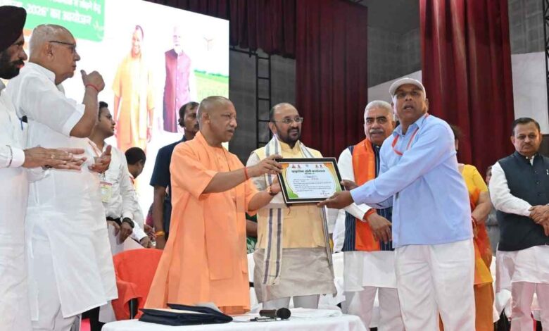 मुख्यमंत्री योगी आदित्यनाथ प्रगतिशील किसान फूल सिंह को मंच पर स्मृति चिन्ह और सम्मान पत्र भेंट करते हुए