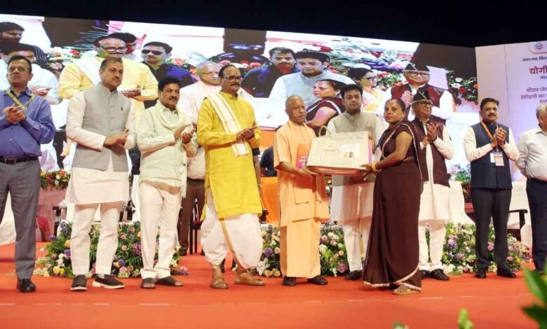 मुख्यमंत्री योगी आदित्यनाथ रसोइयों को कैशलेस चिकित्सा कार्ड और किट वितरित करते हुए